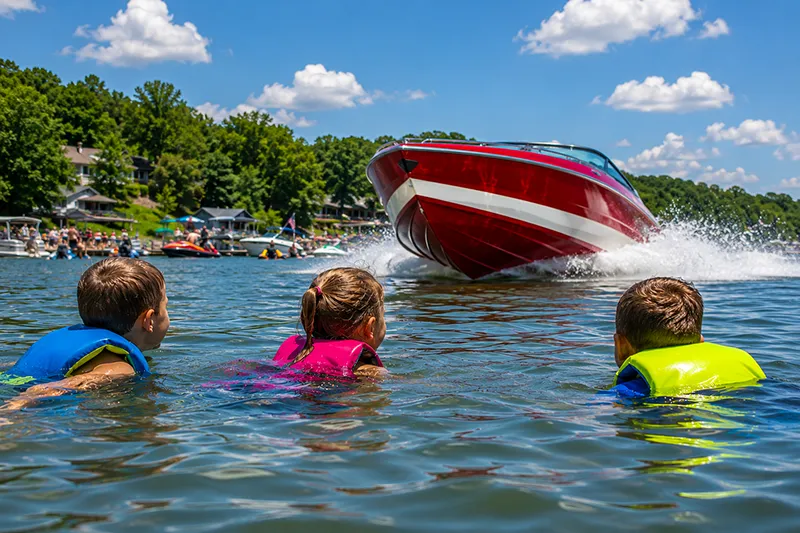 A reckless Oklahoma boat operator speeding toward children swimming in the water on an Oklahoma lake, illustrating how inattentive or unsafe boating can lead to serious accident injuries.